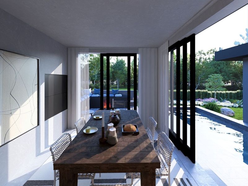 Modern dining area featuring large sliding glass doors that open directly onto a patio and pool area, creating a seamless indoor-outdoor living experience.