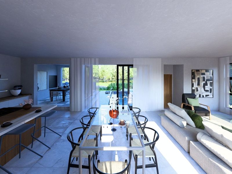 Spacious open-plan living, dining, and kitchen area featuring modern finishes, stone flooring, and large sliding doors opening to the outdoor pool area.