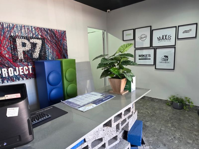 A functional office or reception area featuring a custom stone-topped desk with a cinder block base and modern tiled flooring.