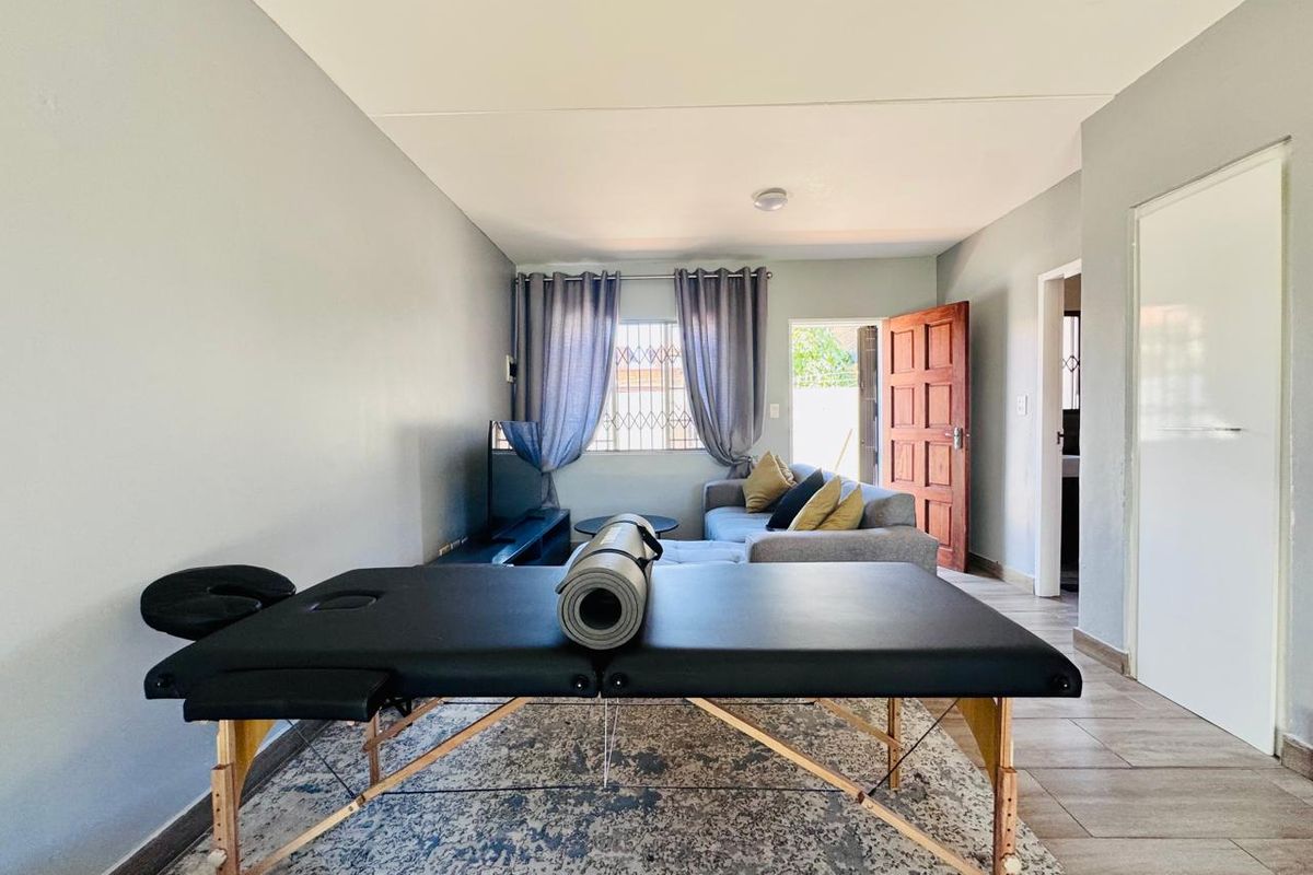 A functional living area featuring tiled flooring and direct access to the exterior, providing a versatile space for relaxation or home activities.