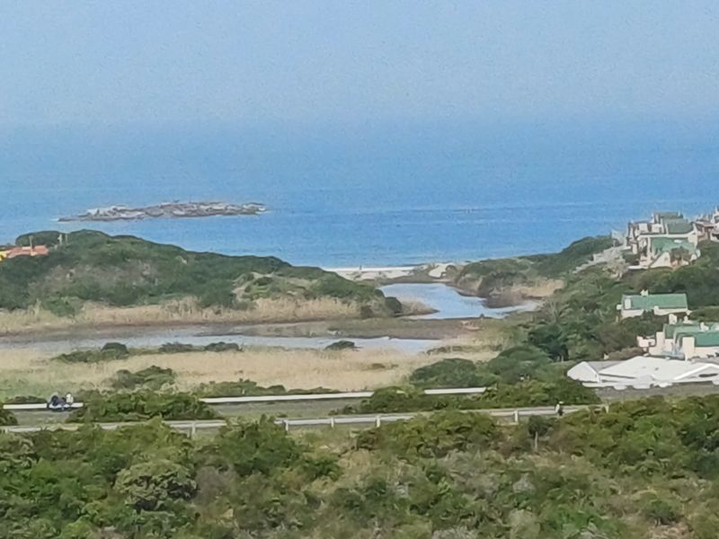A scenic elevated view overlooking the coastal landscape, estuary, and ocean horizon.