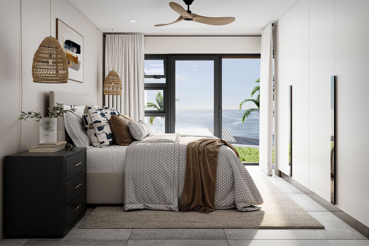Modern bedroom featuring built-in cupboards, tiled flooring, a ceiling fan, and a sliding glass door offering scenic ocean views.