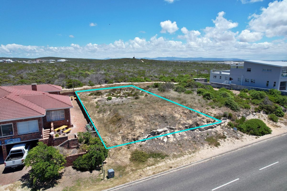 Aerial view of a vacant residential plot with clear boundary markings, situated in a coastal neighborhood setting.