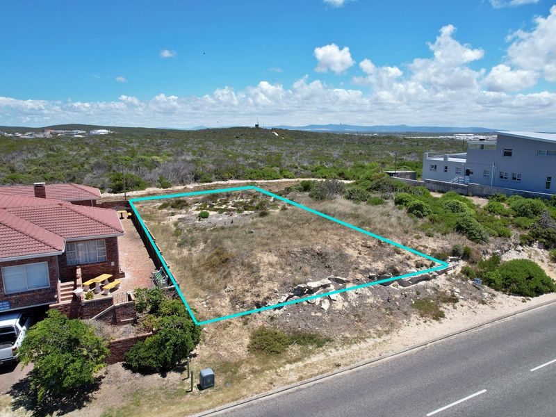 Aerial view of a vacant residential plot with clear boundary markings, situated in a coastal neighborhood setting.