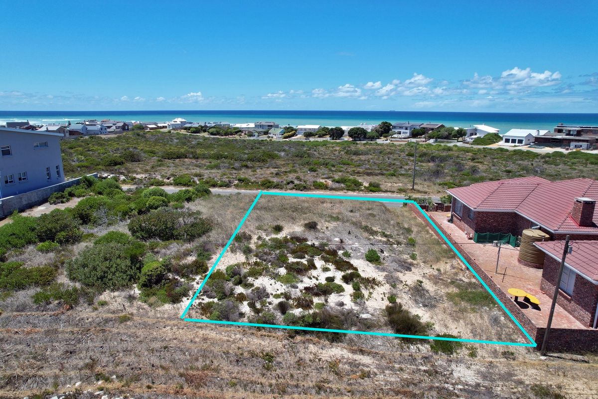 Aerial view of a vacant residential plot featuring coastal vegetation, situated in a prime location with ocean views.