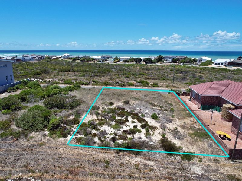 Aerial view of a vacant residential plot featuring coastal vegetation, situated in a prime location with ocean views.
