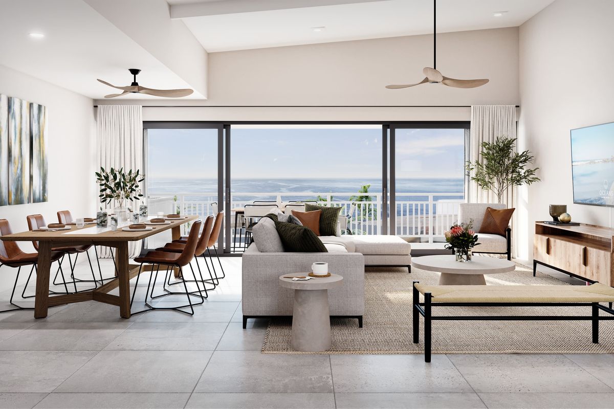 Spacious open-plan living and dining area featuring modern tiled floors, ceiling fans, and large sliding doors opening to an ocean view balcony.