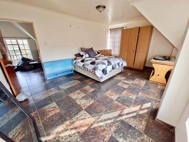 Spacious bedroom featuring tiled flooring, built-in wardrobe storage, and natural light, offering a functional layout ready for personalization.