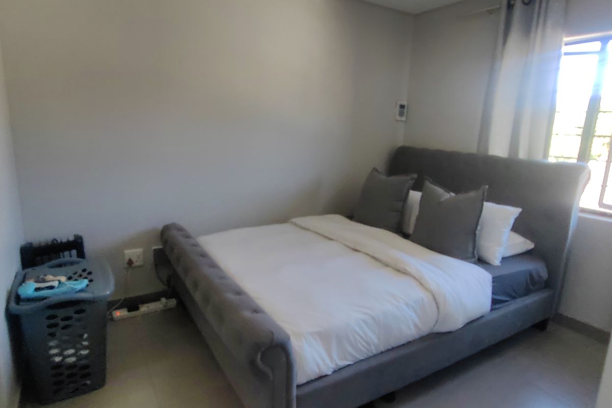 A bedroom featuring tiled flooring, neutral wall finishes, and a window with curtain tracks.