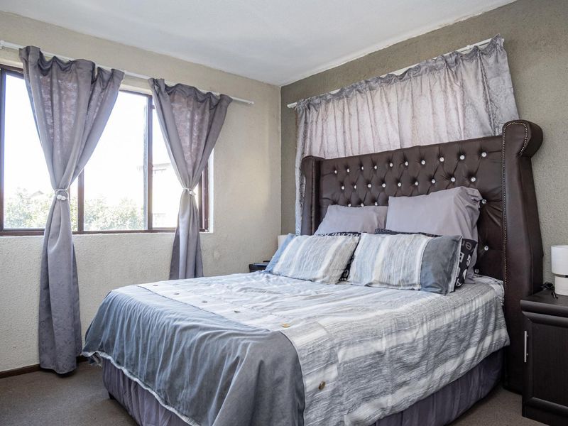 A standard bedroom featuring carpeted flooring and a window, providing a functional space for rest.