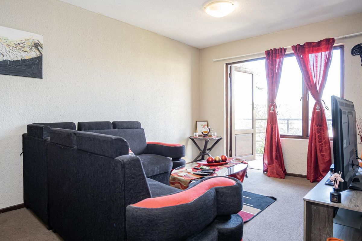 A living room featuring carpet flooring and a sliding glass door providing access to an outdoor area.
