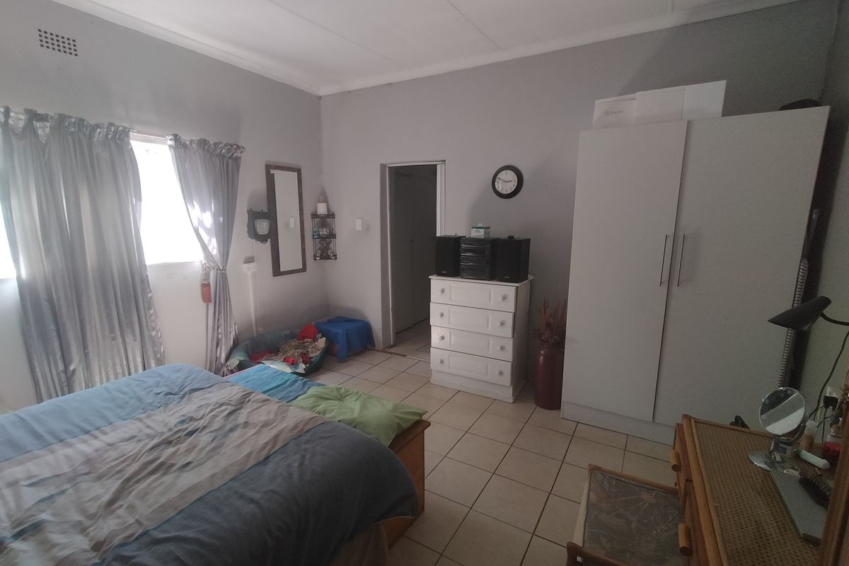 A functional bedroom featuring tiled flooring and a built-in wardrobe, offering a neutral base for personalization.