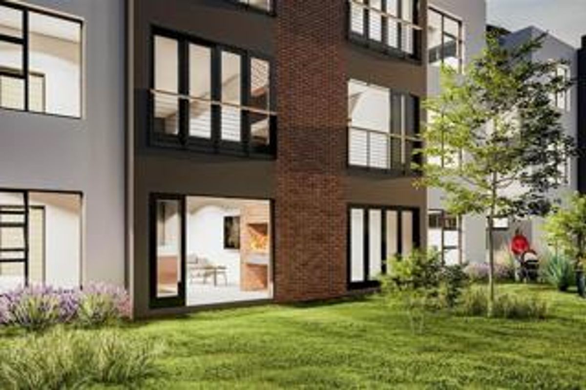 Modern apartment building exterior featuring brick accents, private balconies, and large sliding glass doors opening onto a landscaped garden area.