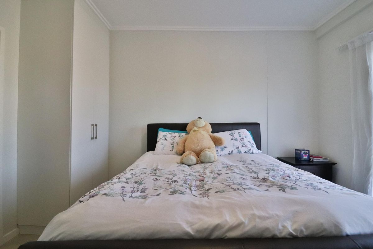 A bedroom featuring built-in floor-to-ceiling wardrobes and neutral wall finishes.