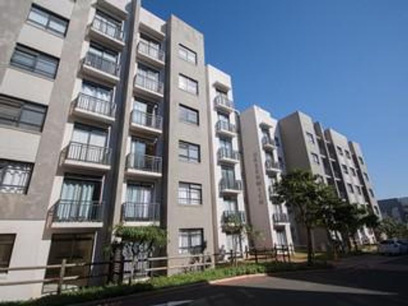 A modern multi-story apartment building featuring a contemporary facade with balconies, large windows, and well-maintained exterior finishes.