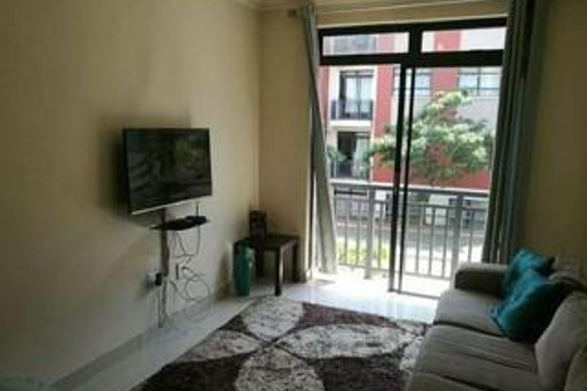 A living room featuring a sliding glass door leading to a balcony, providing natural light and access to outdoor space.