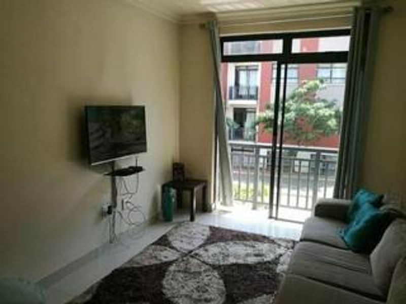 A living room featuring a sliding glass door leading to a balcony, providing natural light and access to outdoor space.