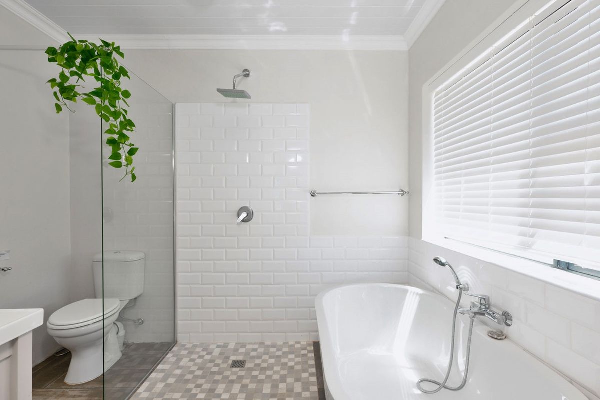 Modern bathroom featuring a freestanding bathtub, a spacious walk-in shower with subway tiling, and clean, contemporary finishes throughout.