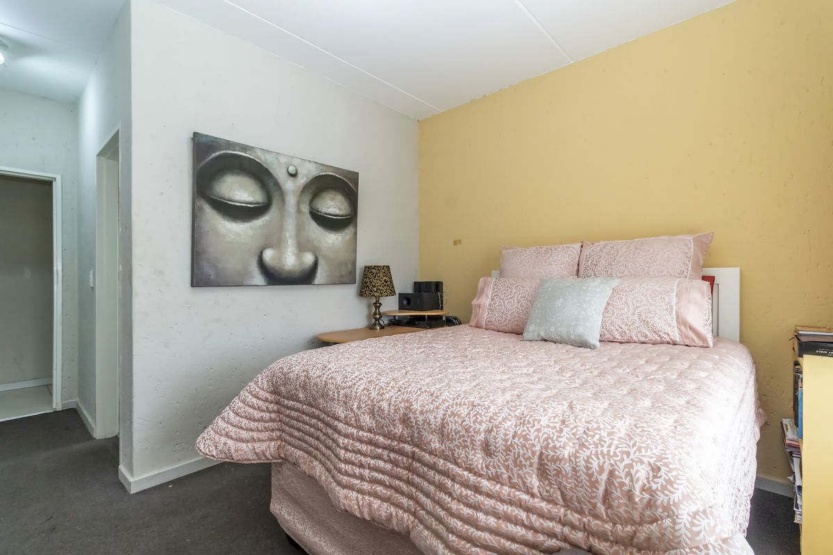 A bedroom featuring carpeted flooring and a combination of white and yellow painted walls.