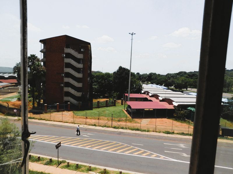 An elevated view from the property overlooking the surrounding neighbourhood, street, and adjacent residential apartment complex.