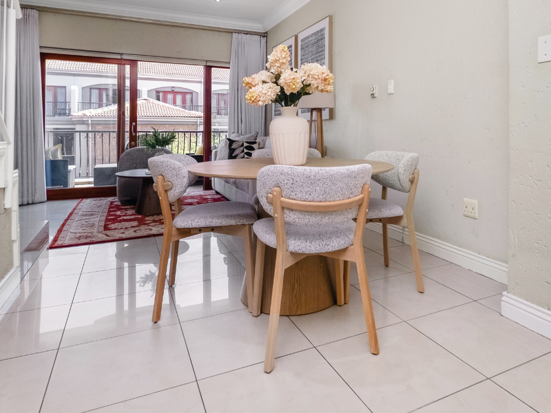Bright open-plan living and dining area featuring large sliding glass doors that provide access to a balcony and allow for ample natural light.
