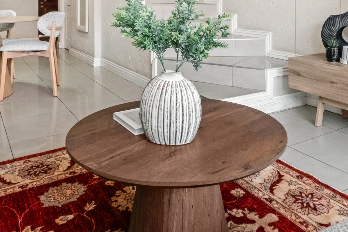 A bright living area featuring neutral tiled flooring and a staircase, creating an open and inviting atmosphere.