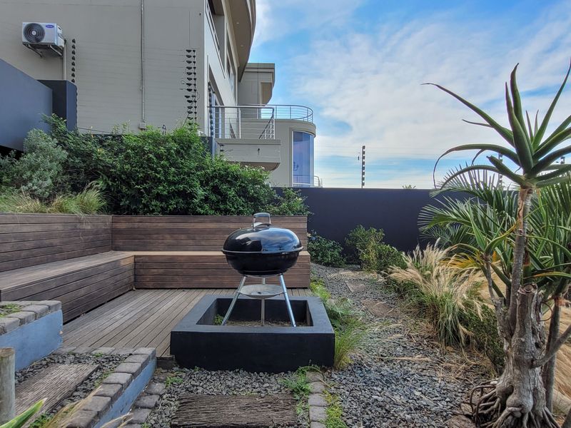 Outdoor patio area featuring timber decking, built-in bench seating, and landscaped garden elements, providing a functional space for outdoor relaxation.