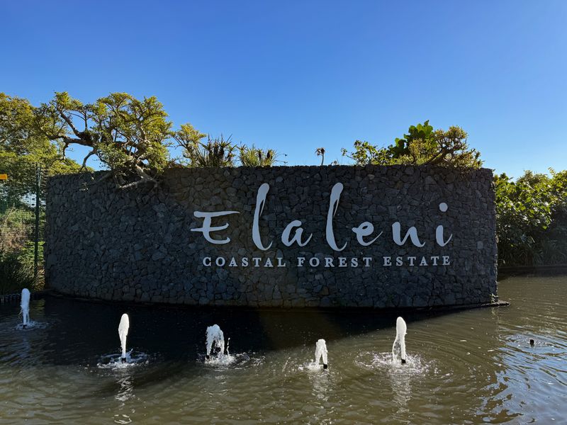 The entrance signage and water feature of the Elaleni Coastal Forest Estate, featuring a stone-clad wall and landscaped surroundings.