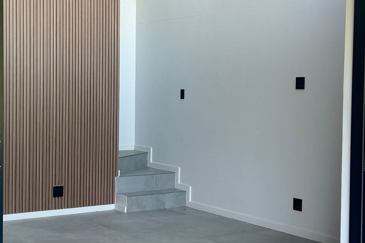 Modern interior space featuring large format floor tiles, a decorative timber-look slat feature wall, and a wall-mounted air conditioning unit.
