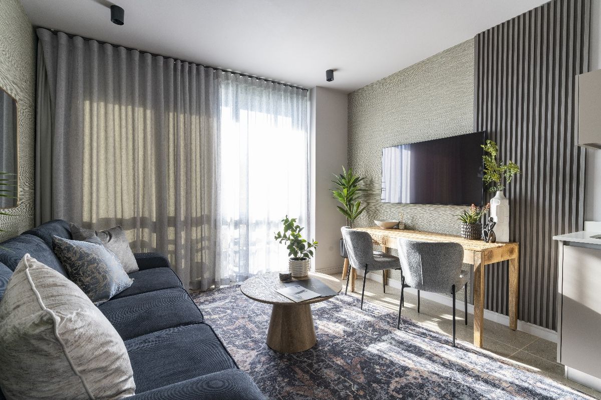A modern, well-appointed living area featuring textured feature walls, floor-to-ceiling curtains, and integrated lighting, creating a sophisticated and comfortable atmosphere.