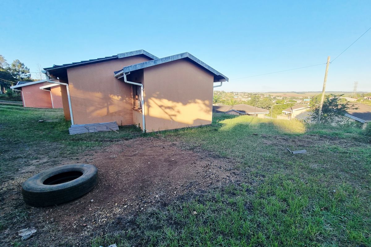 Exterior view of the rear of the house showing the building structure, surrounding yard area, and distant neighborhood views.
