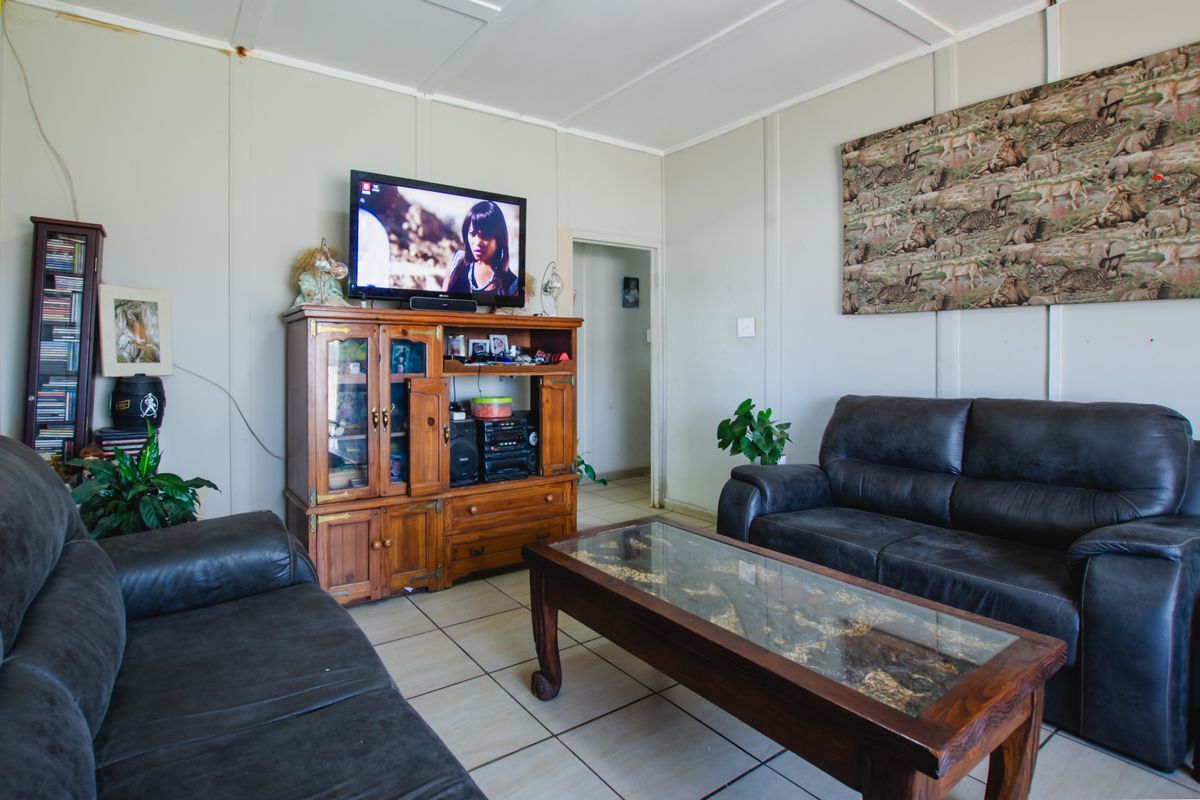 A living room featuring tiled flooring and panelled walls, providing a functional space for relaxation.