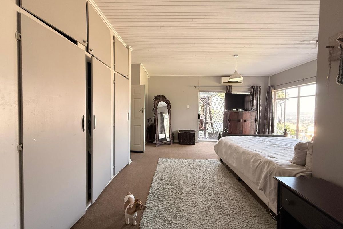Spacious bedroom featuring extensive built-in cabinetry, large windows with natural light, and direct access to an outdoor area.