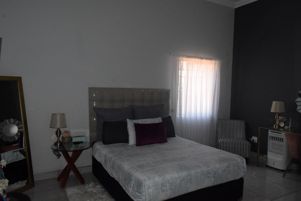 A bedroom featuring tiled flooring and a dark accent wall, providing a neutral base for interior design updates.