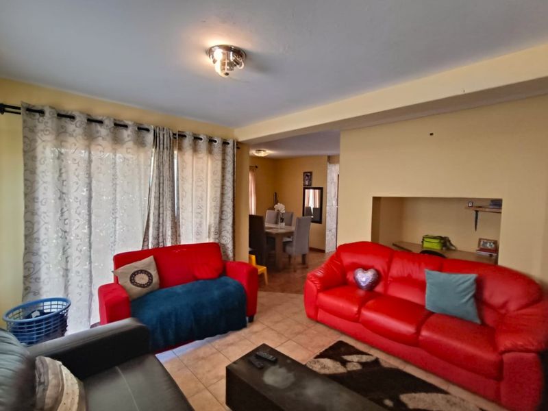 Open plan living and dining area featuring tiled flooring, a recessed wall niche, and sliding glass doors providing access to the exterior.