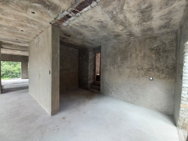 An unfinished interior space in shell condition, featuring raw concrete walls and ceilings, ready for custom renovation and interior finishing.