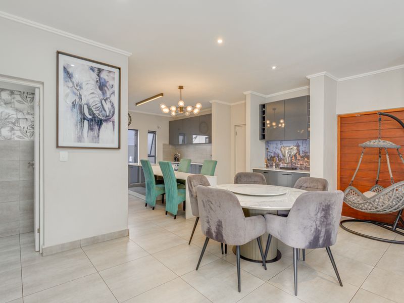 Open-plan living and dining area featuring modern tiled flooring, recessed lighting, and a built-in bar unit with integrated cabinetry.