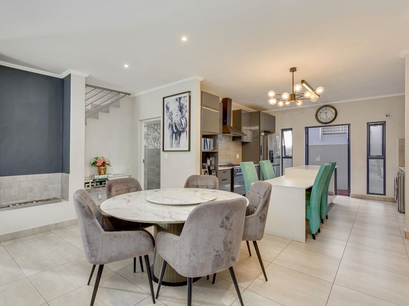 Spacious open-plan living and dining area featuring a modern kitchen with island, built-in fireplace, and contemporary finishes throughout.