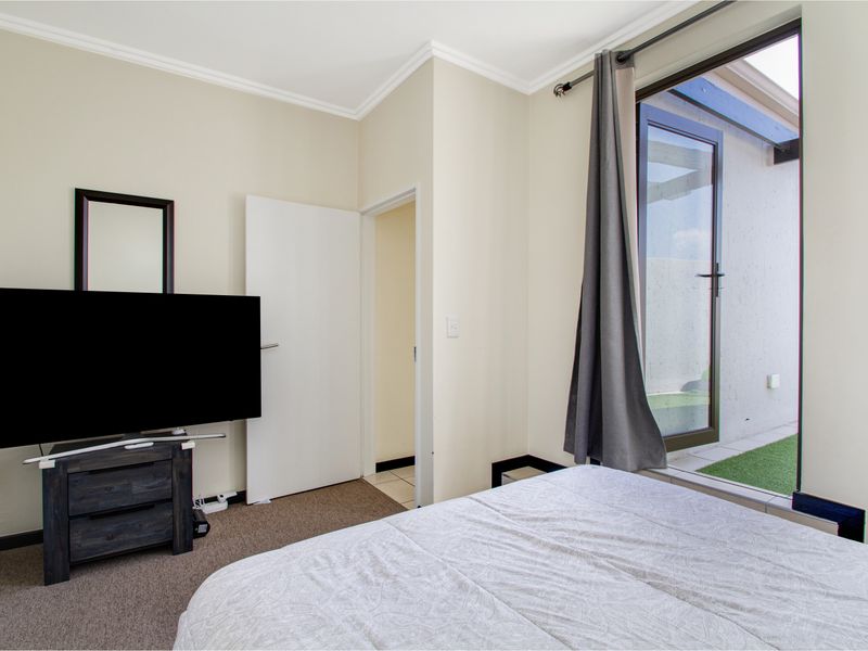 Bedroom featuring carpet flooring, cove cornice, and a sliding glass door providing direct access to an outdoor patio area.