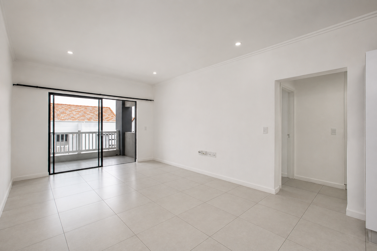 A bright, spacious, and empty living area featuring neutral tiled flooring, recessed lighting, and direct access to a private balcony through sliding glass doors.