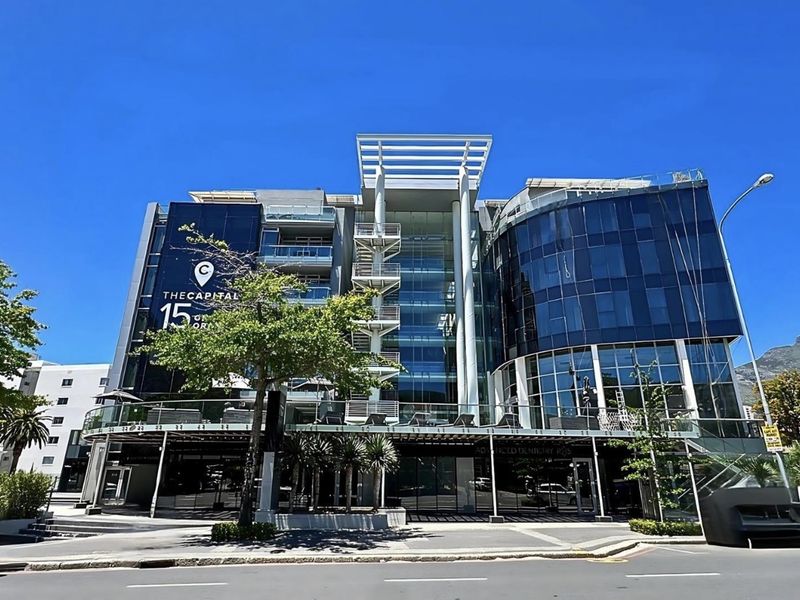 Front elevation of a modern multi-story penthouse building featuring glass facade, external staircases, and balconies.