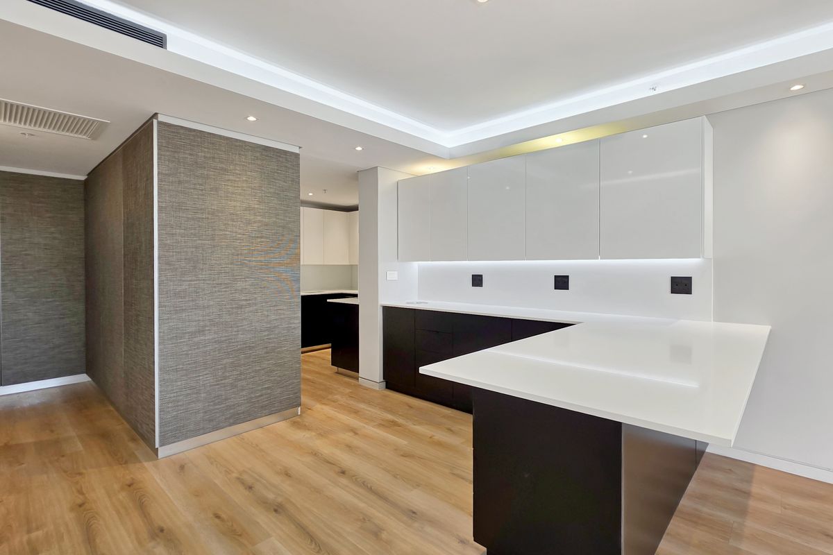 Modern, high-end kitchen featuring sleek handleless cabinetry, stone countertops, integrated lighting, and premium finishes in a clean, minimalist design.