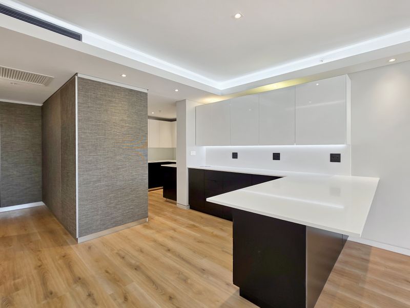 Modern, high-end kitchen featuring sleek handleless cabinetry, stone countertops, integrated lighting, and premium finishes in a clean, minimalist design.