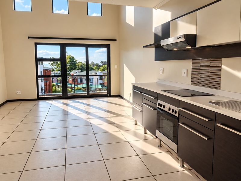 Spacious open-plan living area featuring tiled floors, high ceilings with clerestory windows, and a modern kitchen with built-in appliances and sliding door access.