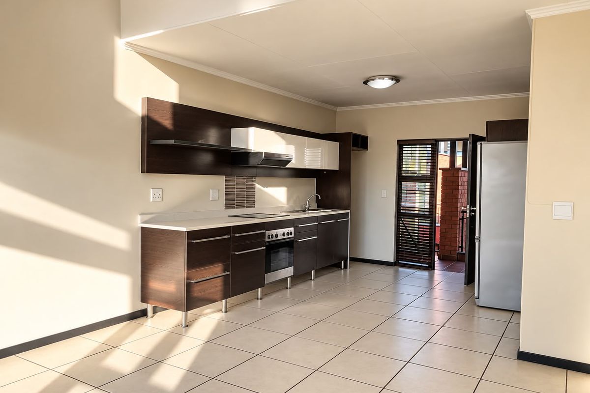 Modern kitchen featuring dark wood cabinetry, built-in oven and hob, tiled flooring, and direct access to an outdoor balcony area.