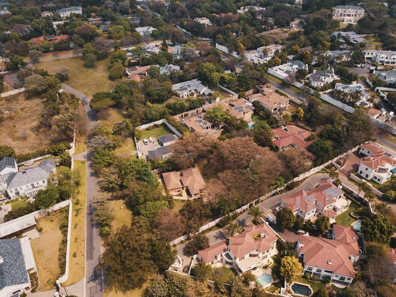 An aerial view of a well-established residential neighborhood featuring mature trees, paved streets, and surrounding properties.
