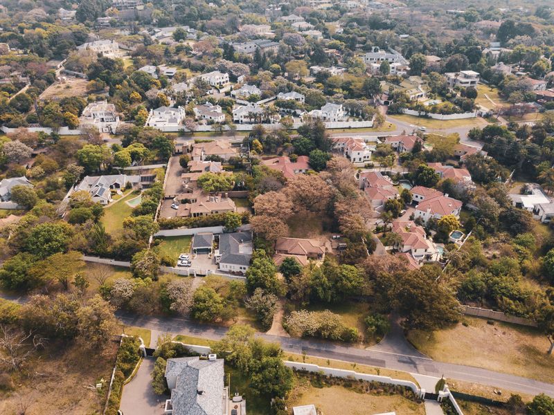 An aerial view of a well-established residential neighborhood featuring mature trees, paved streets, and surrounding properties.