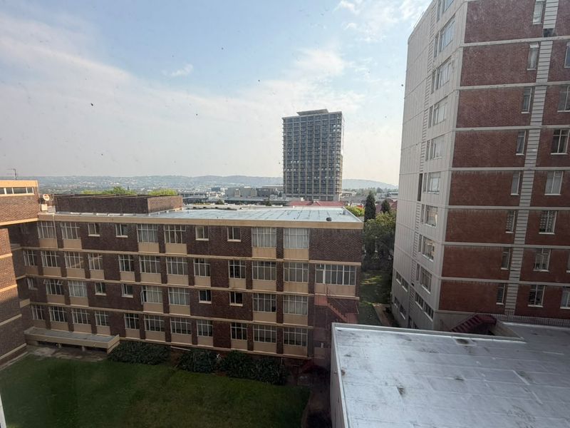 An elevated urban view overlooking surrounding apartment complexes and a shared courtyard area.