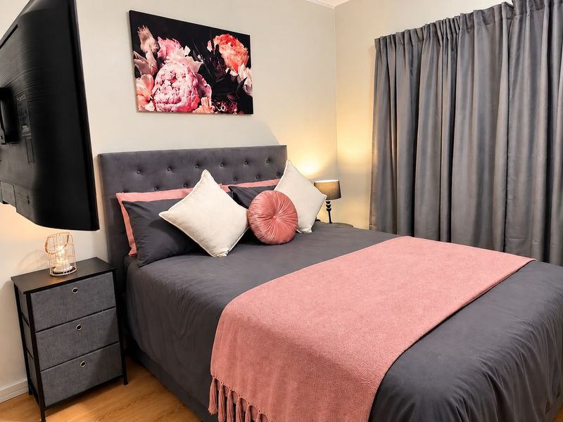 A well-maintained bedroom featuring laminate flooring and neutral wall finishes, providing a comfortable and inviting sleeping space.