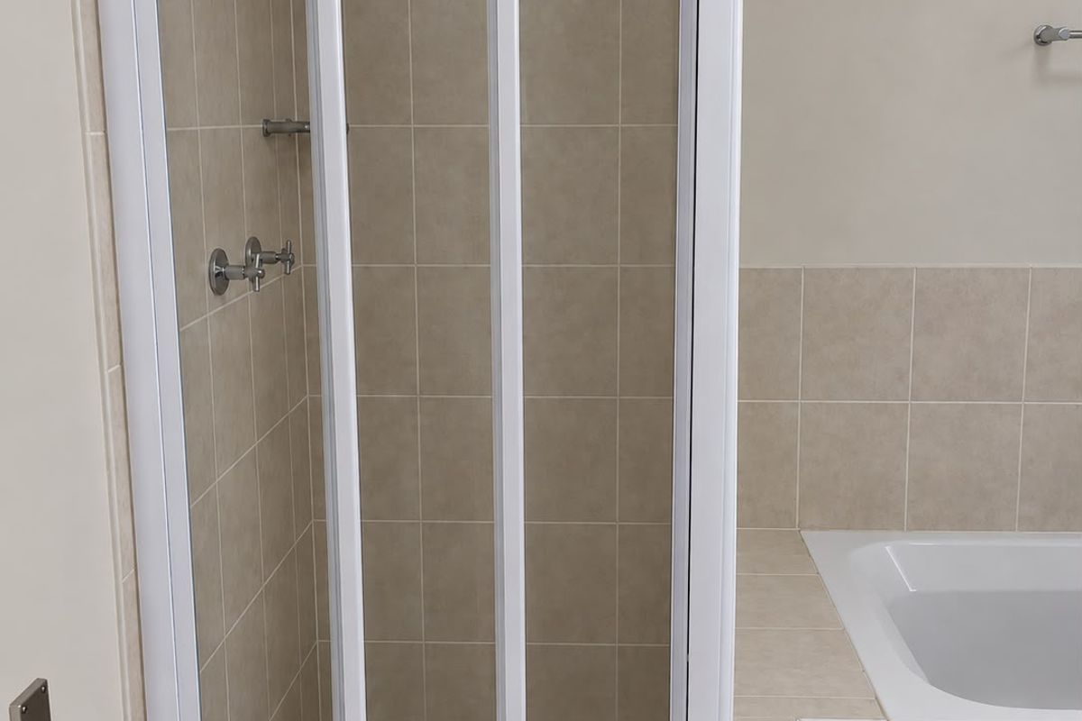 A clean bathroom featuring a built-in bathtub and a separate shower enclosure with neutral ceramic tiling throughout.